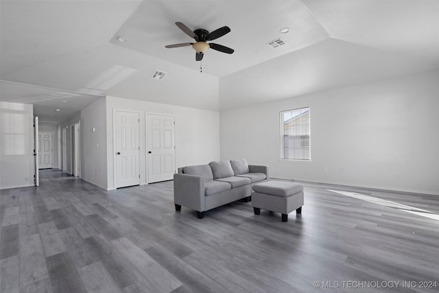 living room with dark hardwood / wood-style flooring, ceiling fan, and vaulted ceiling