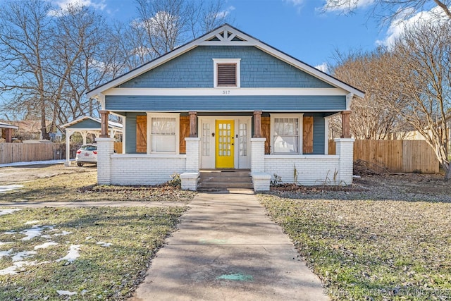 bungalow-style home featuring covered porch and a carport