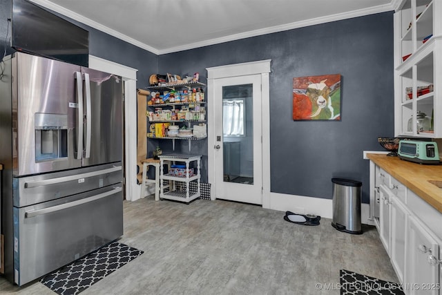 kitchen featuring light hardwood / wood-style floors, stainless steel fridge, white cabinetry, and crown molding