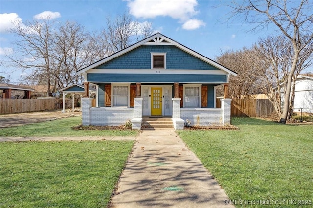 bungalow-style home with covered porch and a front yard