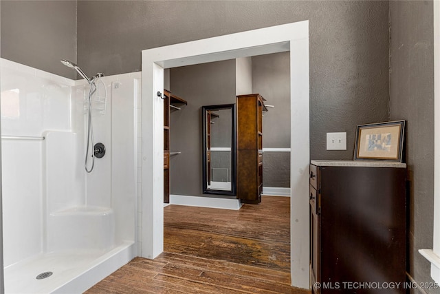 bathroom featuring hardwood / wood-style flooring and a shower