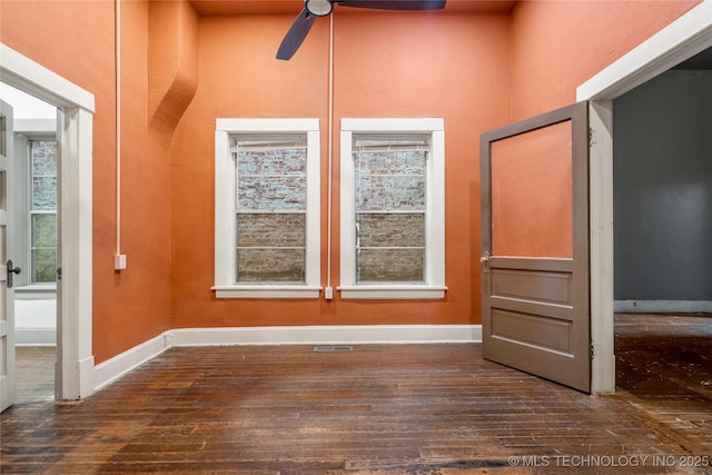 empty room with dark hardwood / wood-style flooring and ceiling fan