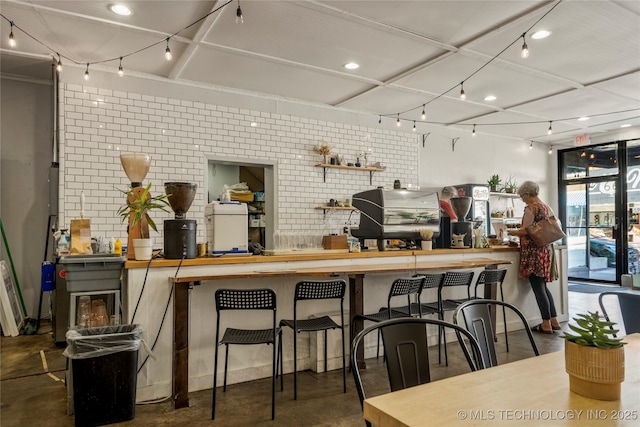 kitchen with a breakfast bar area and brick wall