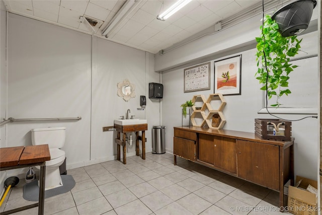 bathroom featuring toilet, tile patterned flooring, and sink