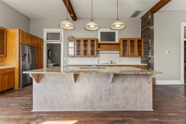 kitchen featuring a breakfast bar area, dark hardwood / wood-style flooring, decorative backsplash, stainless steel refrigerator with ice dispenser, and beam ceiling