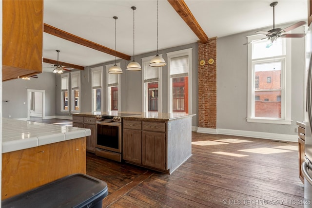 kitchen featuring electric stove, hanging light fixtures, dark wood-type flooring, a kitchen island, and beam ceiling