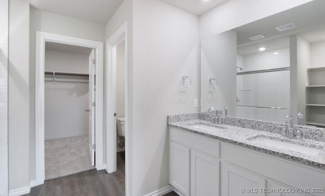 bathroom featuring walk in shower, vanity, toilet, and hardwood / wood-style floors