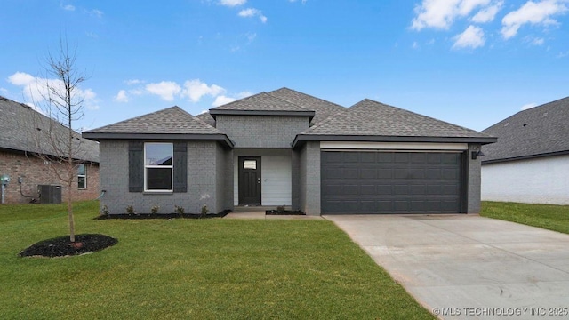 view of front of house featuring cooling unit, a garage, and a front lawn