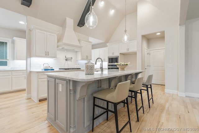 5809 E 126th Pl S, Tulsa, OK 74008 - kitchen featuring premium range hood, white cabinets, decorative backsplash, a large island, and stainless steel microwave