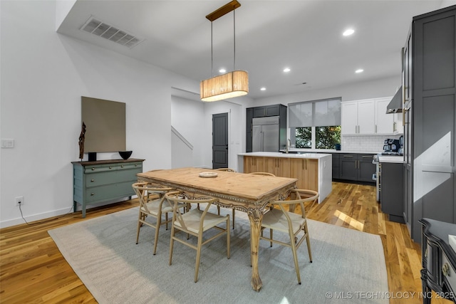 dining area with sink and light wood-type flooring