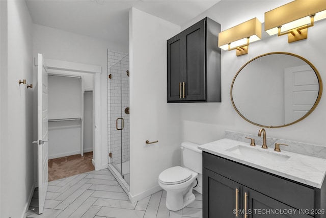 bathroom with toilet, vanity, and a shower with shower door