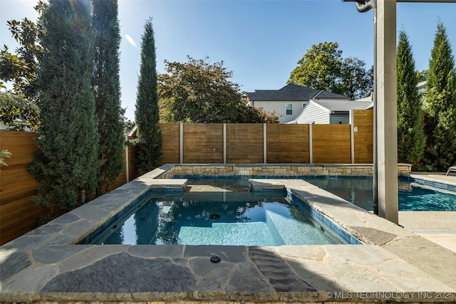 view of pool with an in ground hot tub