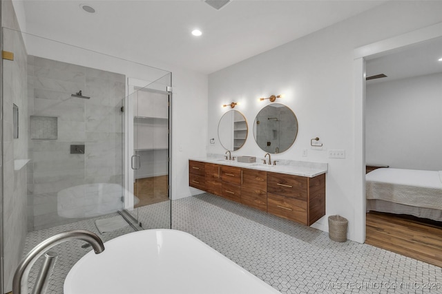 bathroom featuring vanity, hardwood / wood-style flooring, and plus walk in shower