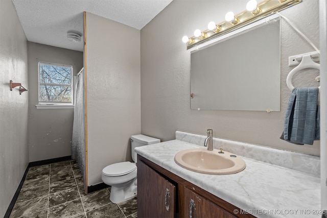 bathroom featuring vanity, toilet, and a textured ceiling