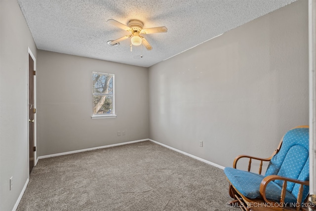 unfurnished room featuring ceiling fan, carpet floors, and a textured ceiling