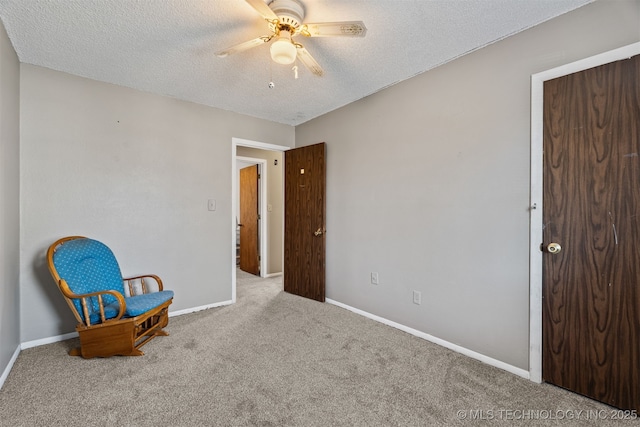 living area featuring a textured ceiling, light colored carpet, and ceiling fan