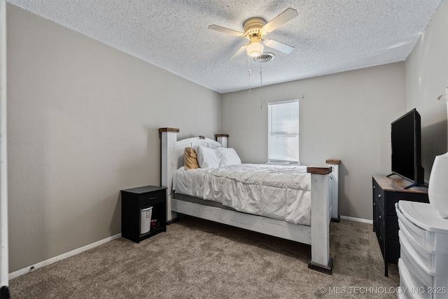 bedroom with ceiling fan, carpet floors, and a textured ceiling