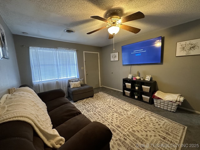 carpeted living room with ceiling fan and a textured ceiling