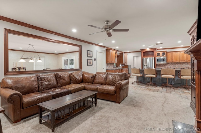 living room featuring ornamental molding, ceiling fan, and light carpet