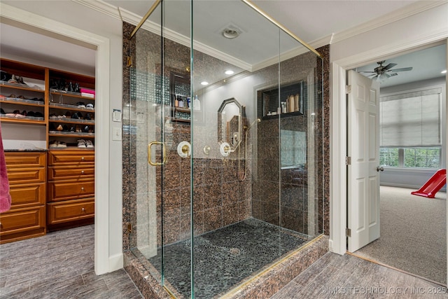 bathroom with ceiling fan, crown molding, and a shower with shower door