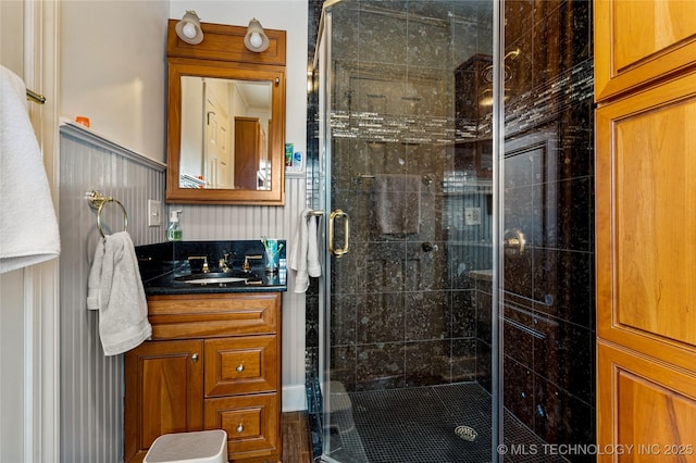 bathroom featuring a shower with shower door and vanity