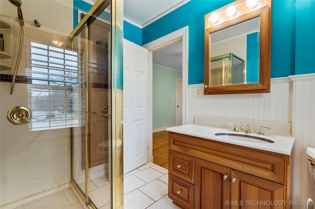 bathroom with tile patterned flooring, a shower with shower door, ornamental molding, toilet, and vanity