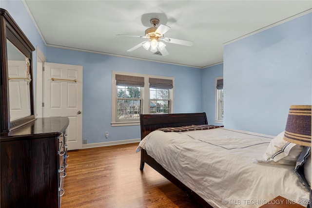 bedroom with hardwood / wood-style floors, ceiling fan, and crown molding