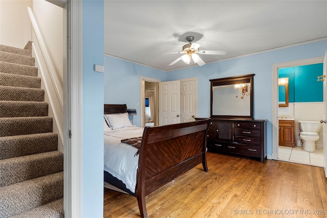 bedroom with ensuite bath, ceiling fan, and hardwood / wood-style flooring