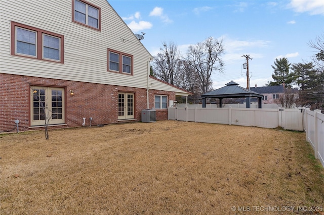 rear view of property featuring a lawn, french doors, cooling unit, and a gazebo