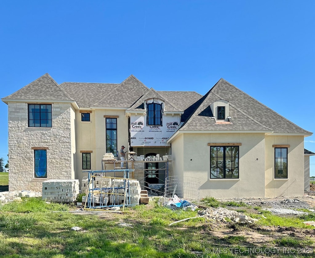 223 W 172nd St S, Mounds, OK 74047 - rear view of house with stucco siding, roof with shingles, and stone siding