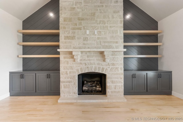 223 W 172nd St S, Mounds, OK 74047 - unfurnished living room featuring lofted ceiling, wood finished floors, and a stone fireplace