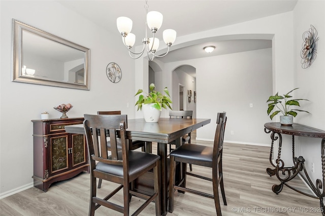 dining area featuring an inviting chandelier and light hardwood / wood-style flooring