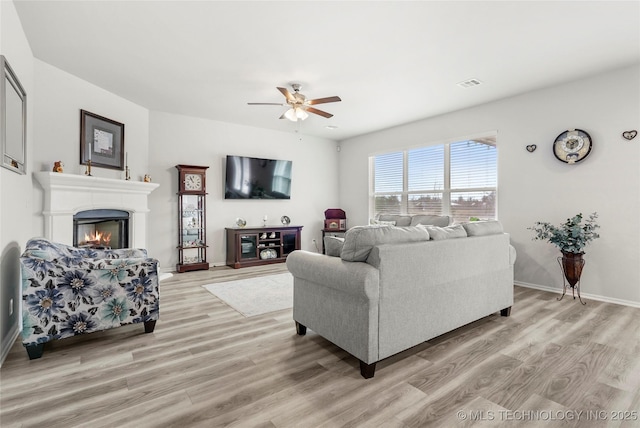 living room with light wood-type flooring and ceiling fan