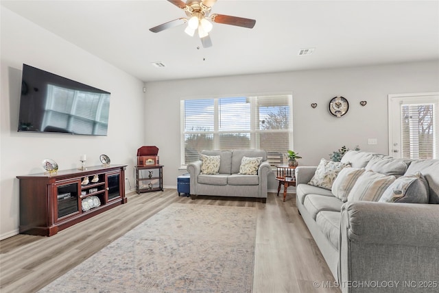 living room with ceiling fan, a healthy amount of sunlight, and light hardwood / wood-style flooring