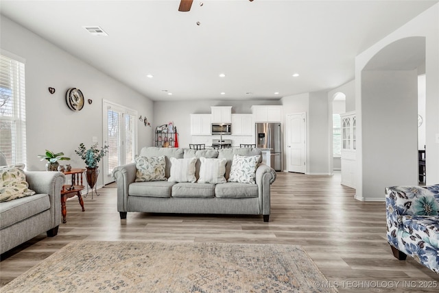 living room featuring ceiling fan, a healthy amount of sunlight, and hardwood / wood-style floors