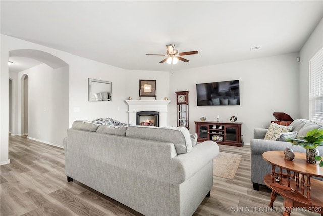 living room featuring ceiling fan and light hardwood / wood-style floors