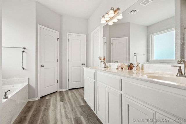 bathroom featuring a washtub, hardwood / wood-style floors, and vanity