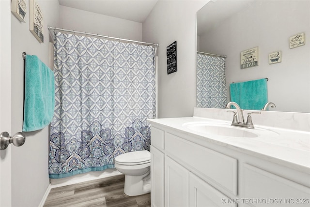 bathroom with toilet, vanity, and hardwood / wood-style floors