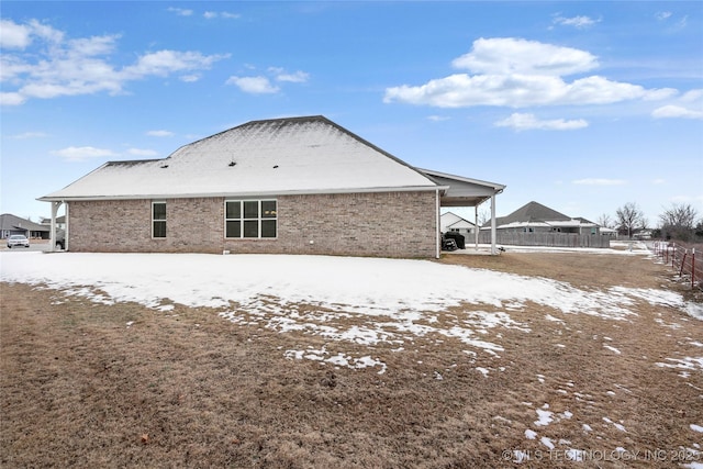 snow covered property featuring a carport