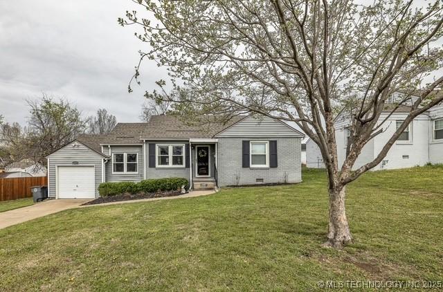 single story home featuring a front yard and a garage