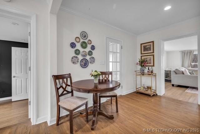 dining room featuring ornamental molding and hardwood / wood-style floors