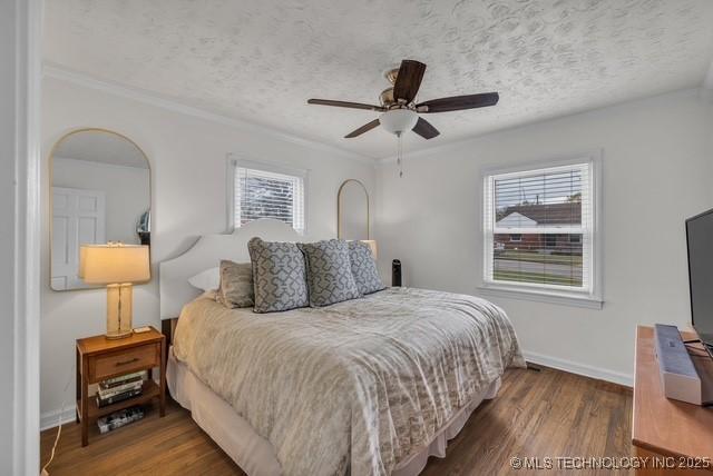 bedroom with dark hardwood / wood-style flooring, multiple windows, a textured ceiling, and ceiling fan