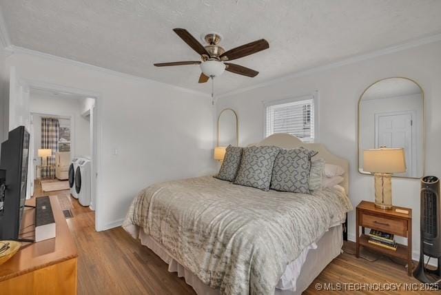 bedroom featuring hardwood / wood-style floors, independent washer and dryer, crown molding, ceiling fan, and a textured ceiling