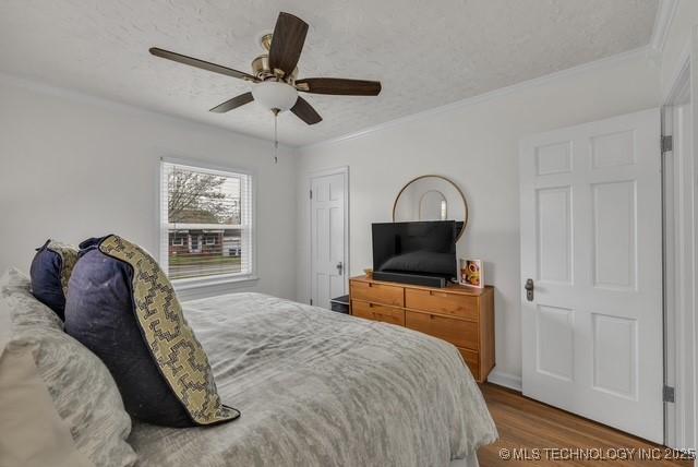 bedroom featuring ceiling fan, crown molding, a textured ceiling, and hardwood / wood-style flooring