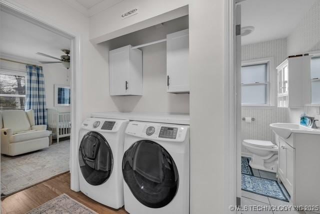 washroom with sink, cabinets, ceiling fan, light hardwood / wood-style floors, and washing machine and dryer