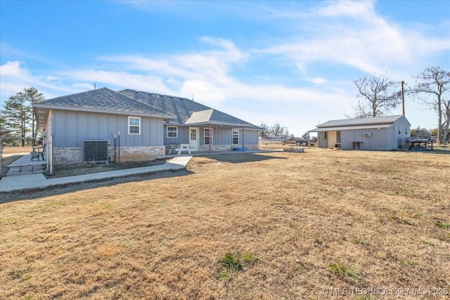 back of house with a lawn and central AC