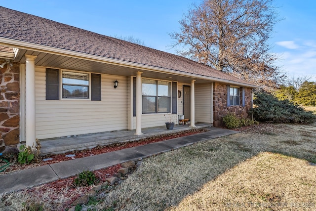 ranch-style home with a front yard and covered porch