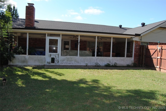 rear view of house with a yard and a sunroom