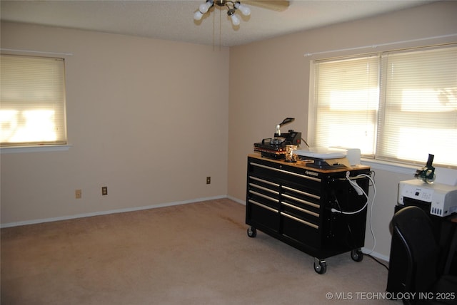 carpeted office space with ceiling fan