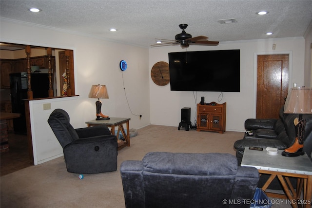 living room featuring a textured ceiling, ceiling fan, crown molding, and carpet flooring